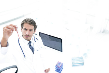 scientific researcher looking at a test tube of blue liquid