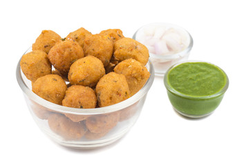 Indian Spicy Street Food Dal Vada Also Know as Moong Dal Vada, Pakoda, Pakode, Pakore, Moong Vada, Pakora or Bhajiya Served with Green Chutney or Onion isolated on White Background