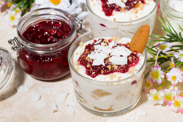 dessert in a glass with cookies, cream and jam, top view