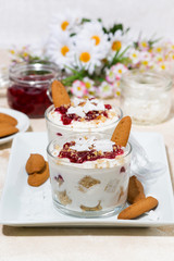 dessert in a glass with cookies, cream and jam, vertical