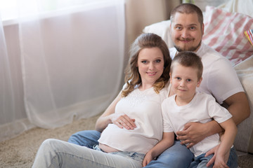 Fototapeta premium Family with a child and a pregnant mother