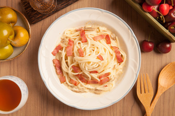 Spaghetti with bacon and cream sauce on plate.
