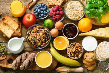 Healthy breakfast ingredients, food frame. Granola, egg, nuts, fruits, berries, toast, milk,...