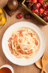 Spaghetti with bacon and cream sauce on plate.