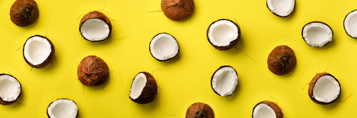 Pattern with ripe coconuts on yellow background. Top View. Copy Space. Pop art design, creative summer concept. Half of coconut in minimal flat lay style.