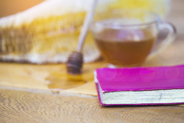 small red bible on wooden table with blurred of a honey cup and honeycomb background, Christian concept show the word of God sweeter than honey