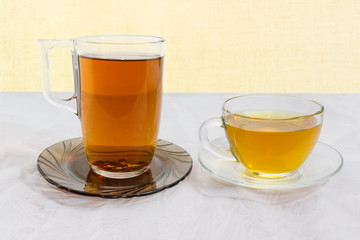 Black and green tea in glass cups on glass saucers