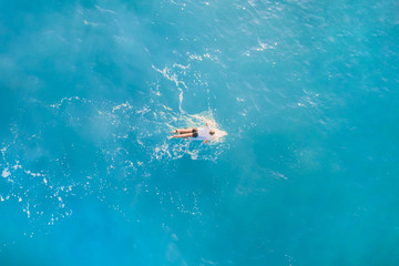Alone surfer in the ocean, top view
