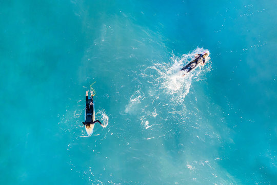 Two surfers in the calm ocean, top view