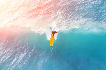 Foto op Plexiglas Surfer on a yellow surfboard in the ocean on a sunny day © watman
