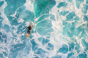 Surfer in the ocean, top view