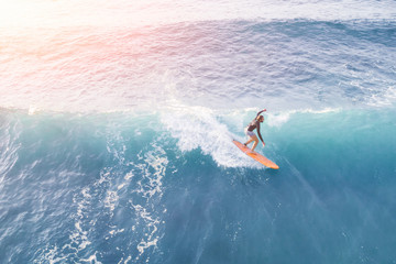 Surfer in the ocean on a sunny day, top view
