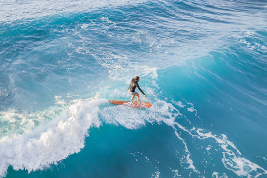 Surfer at the top of the wave in the ocean, top view
