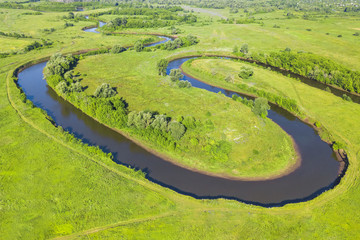 Top view of a winding river in a green valley