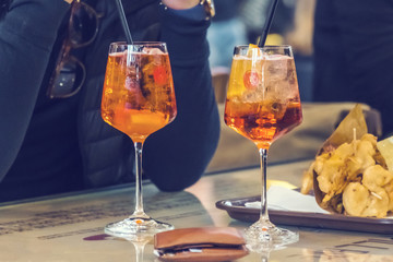 Two cocktails in glasses with straws on the table