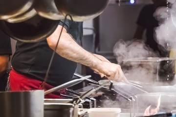 Cook prepares near the stove in the restaurant
