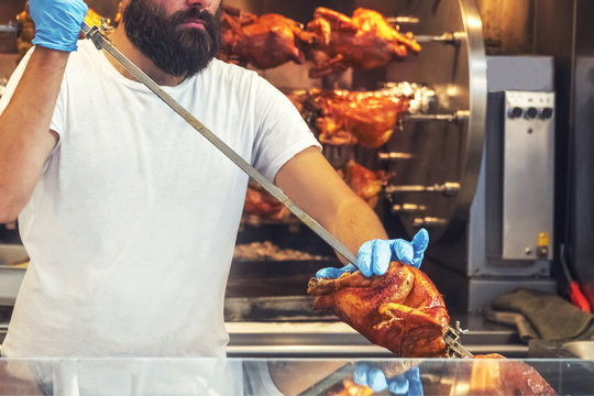 Male chef prepares grilled chicken on a skewer