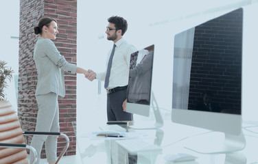 handshake of business partners on background of blank screens
