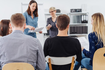 Women lecturing to students or business colleagues