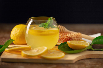 Lemon juice with honey on wooden table,  lemons and sage leaves
