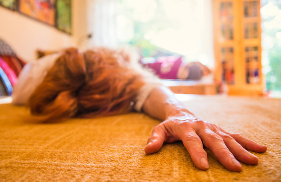 eine Frau liegt bewusstlos auf dem Teppich in einem Raum