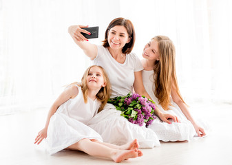 Obraz na płótnie Canvas Happy mother with her pretty little girls making selfie