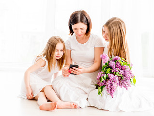 Mother with daughters looking at smartphone