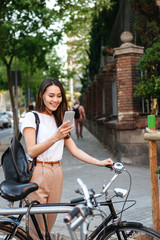 Amazing smiling beautiful woman on bicycle using mobile phone.