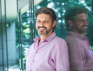 Enthusiastic adult bearded man smiling. Portrait of cheerful businessman