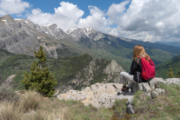 Woman sitting on cliff looking at view