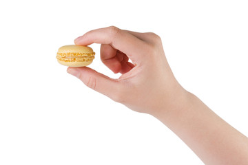 young female hand holding yellow macaron isolated on white