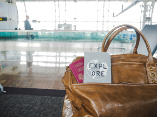 Belgian passport and inspirational passport cover with the quote ' Explore' on a travel bag in a...