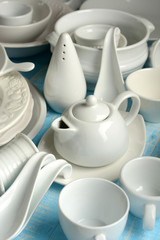 white porcelain kitchenware on light blue wooden table