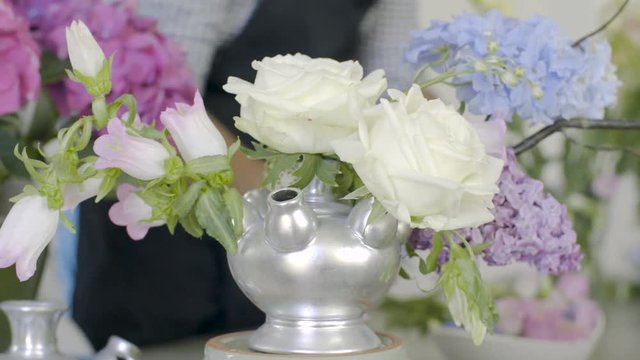 Decoration of white roses and lilac on background of unrecognizable florist