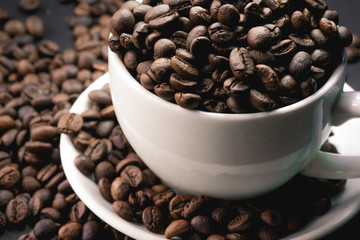 coffee in white cup and coffee beans are the background.