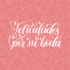 Felicidades Por Su Boda translated from Spanish handwritten phrase Congratulations For Your Wedding on pink background.