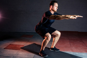young and beautiful sportsman athlete bodybuilder man doing exercises for muscles of the body in the gym. concept of a healthy lifestyle and crossfit