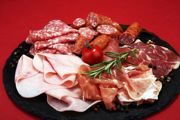 Food tray with delicious salami, ham,  fresh sausages and herbs. Meat platter with selection