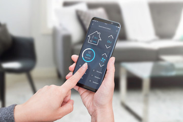 Woman control light in living room interior with smart home control app on modern mobile devices....