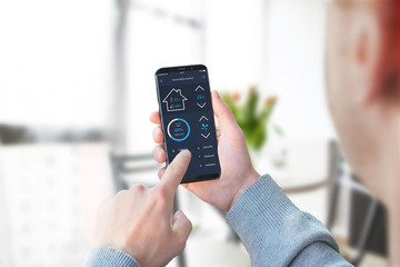 Guy use smart home control app to control lighting in living room interior.