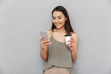 Portrait of a smiling asian woman holding takeaway coffee