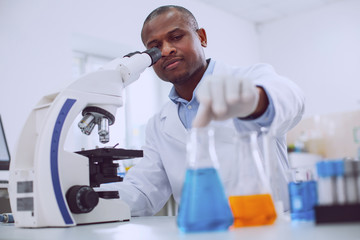 My equipment. Inspired experienced biologist working with his microscope and touching a tube