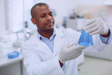 I am happy. Content professional scientist smiling and holding his tube