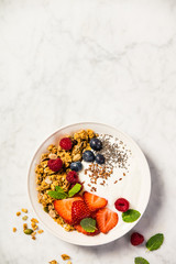 Bowl of homemade granola with yogurt and fresh berries