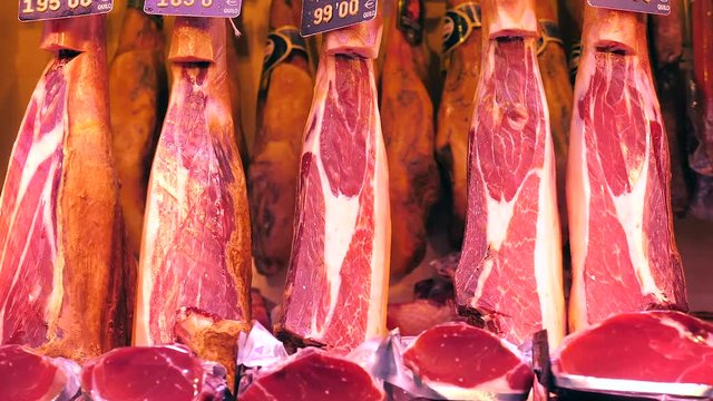 Dry-Cured Ham (Jamon) cuts in La Boqueria market, Barcelona - Dolly shot