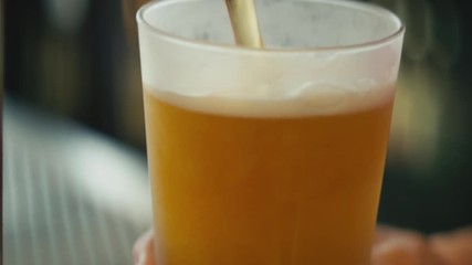 Anamorphic close up beer pouring from top