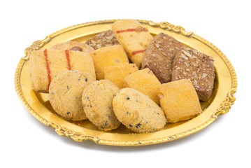 Sweet And Tasty Mixed Cookies or Biscuits Served in Golden Plate Also Know as Nan Khatai, Chocolate Chip Cookie, Cumin Cookie isolated on White Background