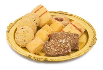 Sweet And Tasty Mixed Cookies or Biscuits Served in Golden Plate Also Know as Nan Khatai, Chocolate Chip Cookie, Cumin Cookie isolated on White Background