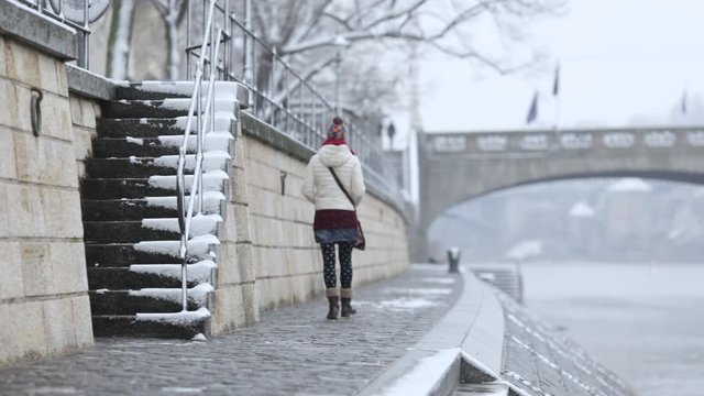 Young girl raising stairs in a snowy urban environment