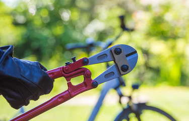 ein Dieb versucht mit einem Werkzeug ein Fahrrad zu stehlen